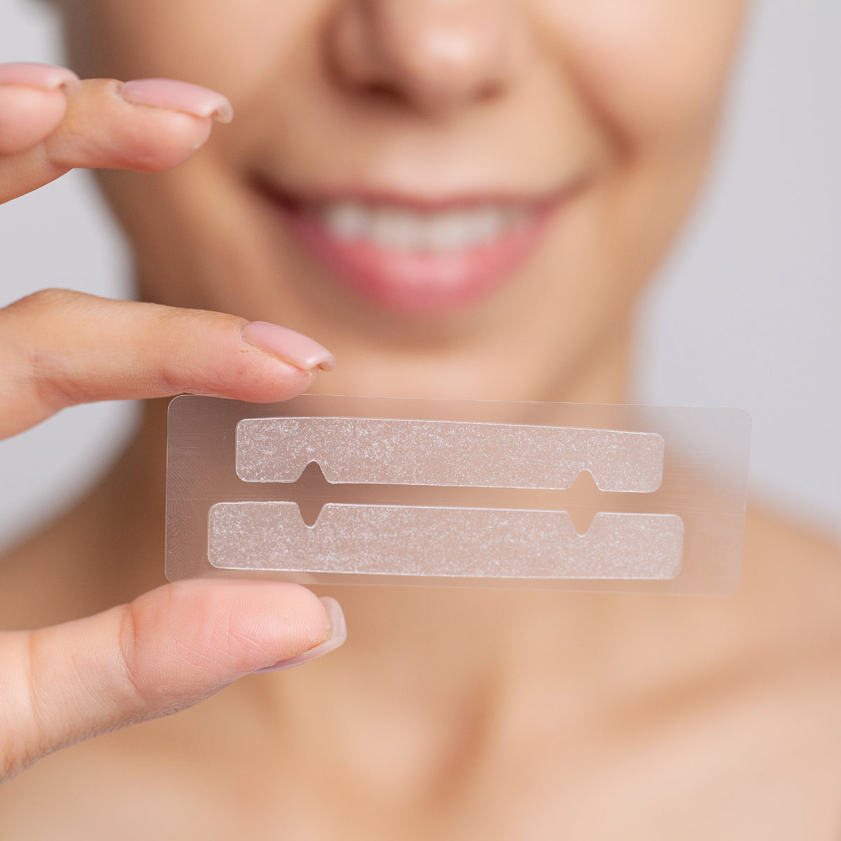 Zbliżenie na pasek wybielający do zębów trzymany w dłoni